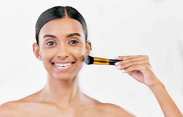 Image showing Portrait, indian woman and brush for face makeup, cosmetics and aesthetic tools on white background, mockup space or studio. Happy female model brushing facial beauty product, foundation and skincare