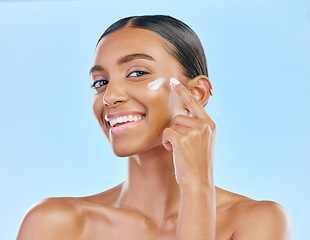 Image showing Face, cream and beauty, woman in portrait with skincare and cosmetics product isolated on blue background. Lotion, sunscreen and facial mask, smile and moisturizer with female model and dermatology