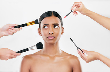 Image showing Makeup, brush and confused woman with beauty shine, overwhelmed with beautician on white background. Anxiety with cosmetics, tools and hands crowd female model in studio, cosmetology and skin glow