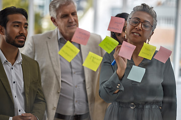 Image showing Meeting, planning and glass with a senior woman leading a presentation in a boardroom for company strategy. Teamwork, presentation and sticky notes in an office with a female manager talking to staff