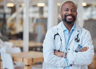 Image showing Portrait, black man and happy doctor with arms crossed in hospital for healthcare. African medical professional, face and surgeon, person or confident employee from Nigeria with smile for wellness.