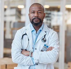 Image showing Portrait, black man and serious doctor with arms crossed in hospital for healthcare. African medical professional, face and surgeon, person or confident employee from Nigeria with wellness career.