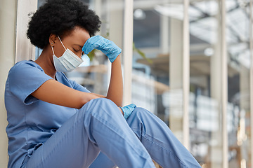 Image showing Sad surgeon, crying and black woman depressed about clinic news, mental health problem or healthcare anxiety. Doctor, headache or African female nurse stress from medical risk, pain and sit on floor