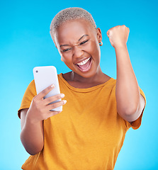 Image showing Surprise, phone and happy black woman excited for announcement, winner notification or good news, alert or promo. Winning, cellphone info and studio person shocked, cheers or wow on blue background