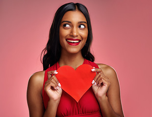 Image showing Thinking, heart and valentines day with a woman on a pink background in studio for love or romance. Idea, red emoji and social media with an excited young female holding a shape or symbol of care