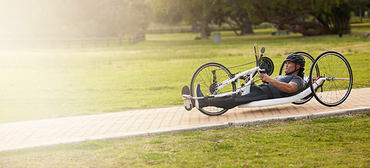 Image showing Cycling, fitness and space with man and handcycle in nature for training, sports contest and challenge. Exercise, workout and banner with person with a disability in park for cardio and health mockup