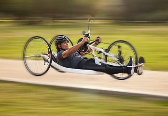 Image showing Cycling, fitness and fast with man and handcycle in nature for training, sports and challenge. Exercise, workout and motion blur with person with a disability in park for cardio and health on road