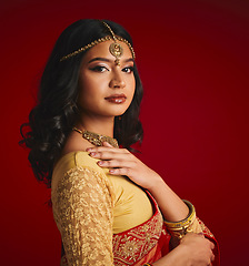 Image showing Fashion, culture and portrait of Indian woman with beauty in traditional clothes, jewellery and sari. Religion, Hindu and face of female person on red background with accessory, cosmetics and makeup