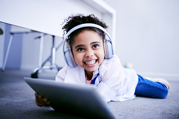 Image showing Tablet, headphones and education with a student girl lying on the floor on her home for distance learning. Technology, virtual class and smile with a happy young female pupil watching a school video