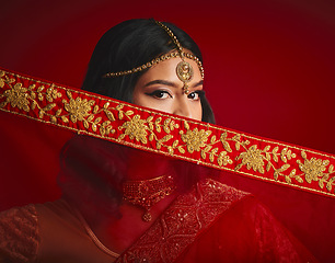 Image showing Fashion, culture and portrait of Indian woman with veil in traditional clothes, jewellery and sari. Religion, beauty and eyes of female person on red background with accessory, cosmetics and makeup