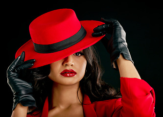 Image showing Fashion, woman and glamour in portrait with red hat or makeup in india with studio background. Elegant female, hidden and face with style with beauty or cosmetics with designer outfit and classy.