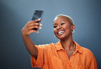 Image showing Selfie, smile and black woman in studio for photography, video call or photo on grey background. Smartphone, happy and lady social media influencer with profile picture, live streaming or blog update