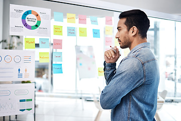 Image showing Creative man, thinking and glass board for project management, marketing or planning at office. Male person, manager or employee checking project plan, tasks or statistics for startup at workplace