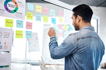 Image showing Creative man, sticky note and glass board for schedule tasks, planning or brainstorming at the office. Male person or employee checking plan, agenda or marketing strategy for startup at the workplace