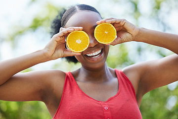 Image showing Happy black woman, vitamin C and orange on eyes for natural nutrition or citrus diet in nature outdoors. Portrait of African female person smile with organic fruit for health and wellness in the park