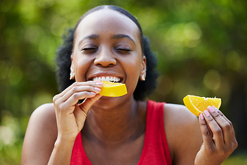 Image showing Black woman, vitamin C and eating orange slice for natural nutrition or citrus diet in nature outdoors. Happy African female person enjoying bite of organic fruit for health and wellness in the park