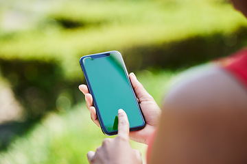 Image showing Woman, hands and phone mockup for advertising, mobile app or communication on green screen in nature. Female person with smartphone display or chromakey for advertisement or marketing in the outdoors