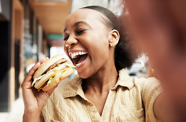 Image showing Burger, eating and woman in selfie, city and restaurant outdoor promotion, social media and live streaming review. Fast food, hungry and african person, customer or influencer with lunch photography