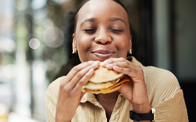 Image showing Restaurant, fast food and black woman eating a burger in an outdoor cafe as a lunch meal craving deal. Breakfast, sandwich and young female person or customer enjoying a tasty unhealthy snack