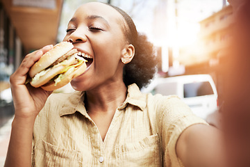 Image showing Burger, eating and black woman in selfie, city and restaurant for outdoor promotion, social media and live streaming review. Fast food, hungry customer, person or influencer with lunch or photography