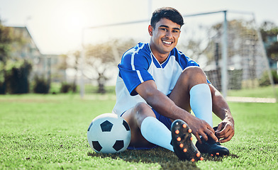 Image showing Man, soccer field and tie shoes for sports training, fitness games and performance on stadium ground. Portrait, athlete and happy football player prepare lace sneakers on grass pitch for competition