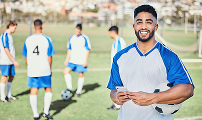 Image showing Football player, phone and portrait at game on a field for sports and fitness app. Happy male soccer or athlete person outdoor for challenge, competition or motivation with online communication