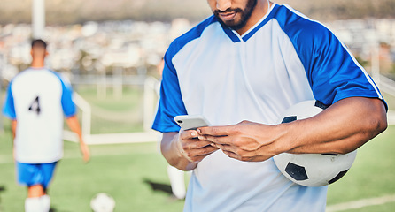 Image showing Soccer field, phone and man hands for competition, training or fitness news, social media chat and blog. Football player or person typing on mobile app for sports information, health or goals check