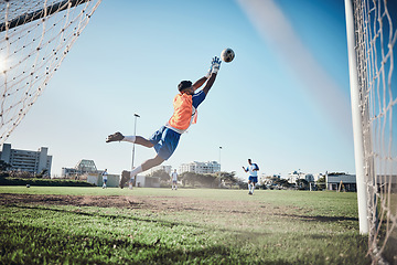 Image showing Fitness, goalkeeper or soccer player taking a penalty in a game or training match at a tournament. Save, back or male football athlete kicking ball at practice on outdoor field or pitch in stadium