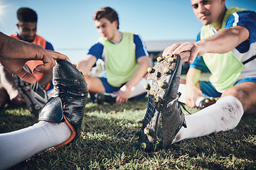 Image showing Football player, stretching and feet of men training on a field for sports game and fitness. Closeup on shoes of male soccer team or athlete group for challenge, workout or exercise outdoor on pitch