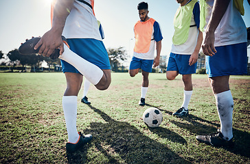 Image showing Stretching legs, football player and men training on a field for sports game and fitness. Male soccer team or athlete group together for challenge, workout or exercise outdoor on a grass pitch