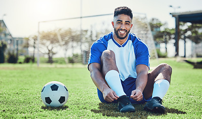 Image showing Sports, man or soccer player tie shoes for training, fitness games and performance on stadium field. Portrait, happy indian athlete or lace football sneakers on grass pitch to prepare for competition