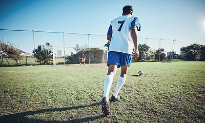 Image showing Sports, penalty and soccer player score a goal at training, game or match at a tournament. Fitness, exercise and back of a male football athlete kicking a ball at practice on outdoor field at stadium