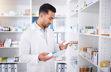 Image showing Medicine inspection, pharmacy and man with a note for medical stock or healthcare in store. Retail, work and male Asian pharmacist reading information on a box of pills with a document for inventory