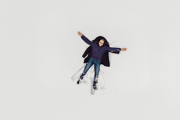 Image showing Aerial view to woman lying in snow