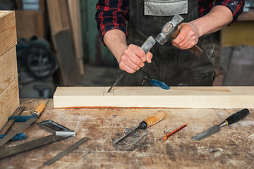 Image showing Carpenter working with a chisel