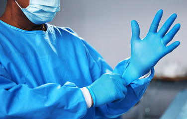 Image showing Doctor with gloves, health and surgeon with PPE, safety and protection from bacteria, operating room and closeup. Medical professional, surgery and treatment with person in hospital and healthcare