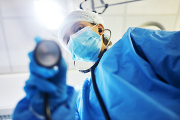 Image showing Covid, surgery and a doctor with a light in the theater for a medical procedure or inspection. Hospital, healthcare and portrait of a surgeon or clinic worker with gear for an emergency consultation