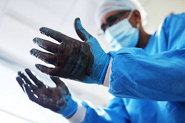 Image showing Blood, gloves and operation with a doctor in the hospital emergency room or operating theatre for surgery. Hands, healthcare or medical with a male medicine professional in a clinic for a procedure