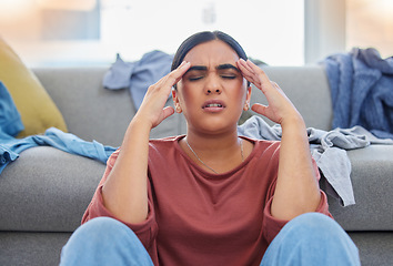 Image showing Headache, stress and woman with depression from laundry in a living room, exhausted and unhappy in her home. Anxiety, migraine and female person frustrated with household, task or spring cleaning