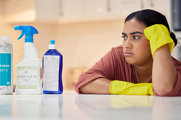 Image showing Cleaning, spray bottle and frown with an annoyed woman housekeeper looking at hygiene products in the kitchen. Depression, housekeeping and supplies with a frustrated female cleaner in a home