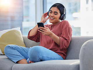 Image showing Relax, music and phone with woman on sofa and dance for streaming, social media and audio. Happy, technology and radio with person listening to headphones in living room at home for energy and sound