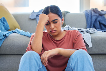 Image showing Headache, depression and woman with stress from laundry in a living room, exhausted and unhappy in her home. Anxiety, migraine and female person overwhelmed with household, task or spring cleaning