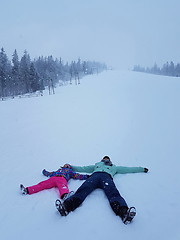 Image showing Daughter and mother are playing and lying in the snow in winter 