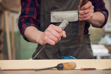 Image showing Carpenter working with a chisel