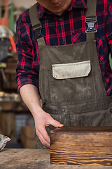 Image showing Carpenter painting wooden