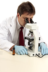 Image showing Researcher viewing substance under microscope