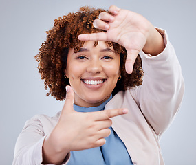 Image showing Hand, frame and happy woman portrait in studio with sign for photo, photography or fun picture on grey background. Face, lady and beauty influencer with emoji finger for social media or selfie smile