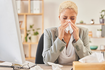 Image showing Computer, tissue and a business woman blowing nose while working at a desk, sick in the office. Cold, flu or symptoms with a young female corporate employee sneezing from hayfever allergies at work