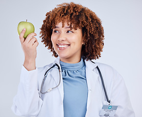 Image showing Doctor, happy woman and holding apple in white background, studio and vitamin c wellness. Medical employee, female nutritionist and smile with green fruits for nutrition, healthy food and vegan diet