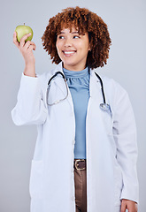 Image showing Doctor, woman and smile with apple in white background, studio and vitamin c wellness. Happy female medical worker, nutritionist and advice of green fruits for nutrition, healthy food and detox diet